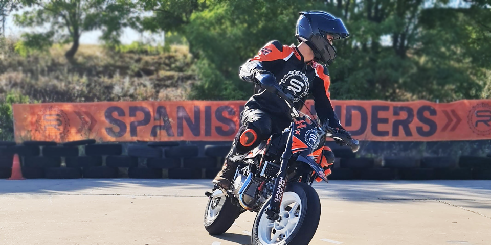 Piloto de moto mostrando rigidez y mirada mal gestionada al trazar una curva con miedo