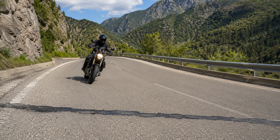moto cruzando una línea transversal de alquitrán en curva